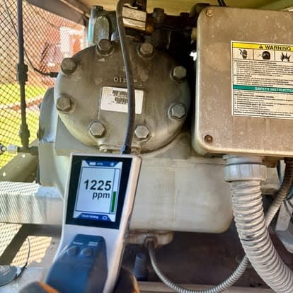 Digital display showing 1225 ppm measurement near industrial equipment motor.