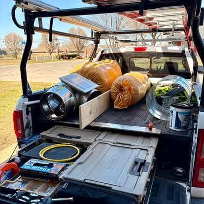 Pickup truck bed filled with tools, materials, and equipment for construction projects.